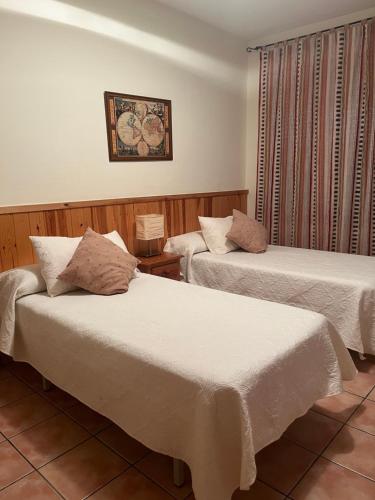 a hotel room with two beds with white sheets at Casa la Cuadreta in Calvera