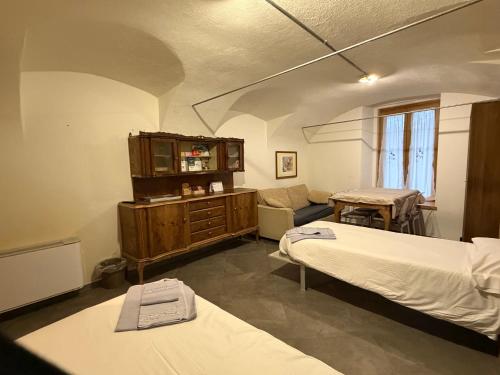 a room with two beds and a cabinet and a chair at B&B Scarpo & Supel in Nona