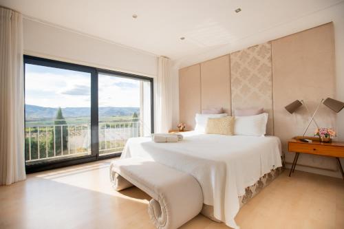 a bedroom with a large bed and a large window at Quinta da Terrincha in Torre de Moncorvo