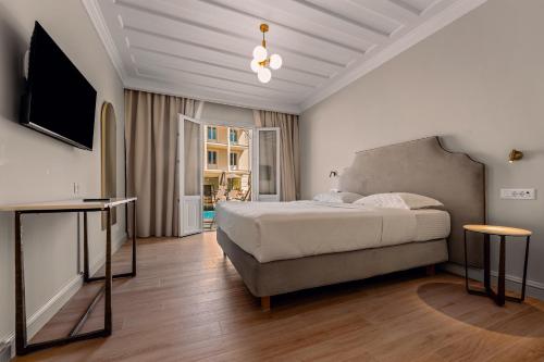 a bedroom with a bed and a flat screen tv at Royal Nidri Suites in Nydri