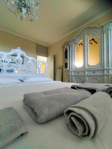 a bedroom with a large white bed with towels on it at Casa Negrita in Bra