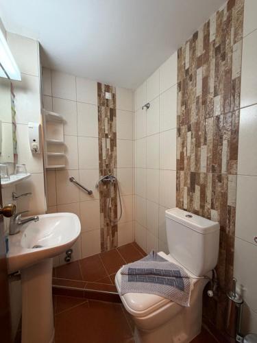 a bathroom with a toilet and a sink at Paradise Hotel in Kos
