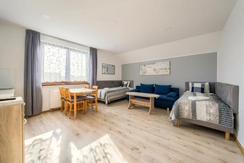 a living room with a blue couch and a bed at Domki letniskowe i pokoje u Katarzyny in Ustronie Morskie