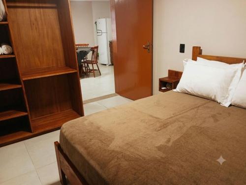 a bedroom with a bed and a door to a kitchen at Casa das Bananeiras - 1 Quarto * Rota do Vinho in Bento Gonçalves