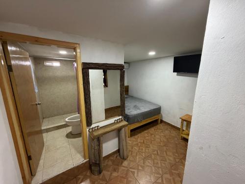 a small bathroom with a bed and a mirror at Hotel Mirador Creel in Creel