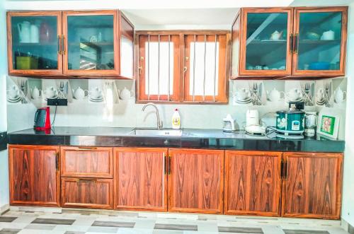 a kitchen with wooden cabinets and a sink at Venuri Villa Midigama in Midigama East