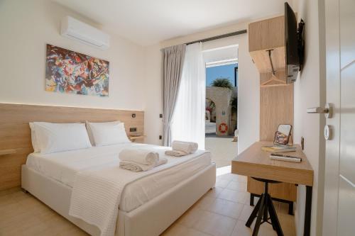 a bedroom with a bed and a desk with towels on it at Marevia in Nopíyia