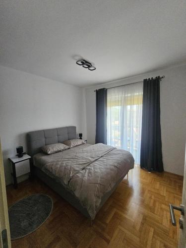 a bedroom with a bed and a large window at Azure Coast in Bar
