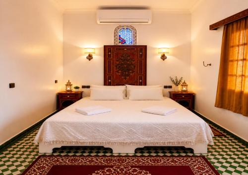 a bedroom with a bed with two towels on it at Dar Albanin in Fez