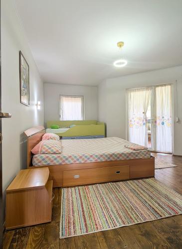 a bedroom with two beds and a rug at Casa la Helesteu in Ocnele Mari