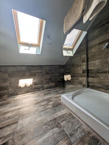 a bathroom with a bath tub and a window at Casa la Helesteu in Ocnele Mari