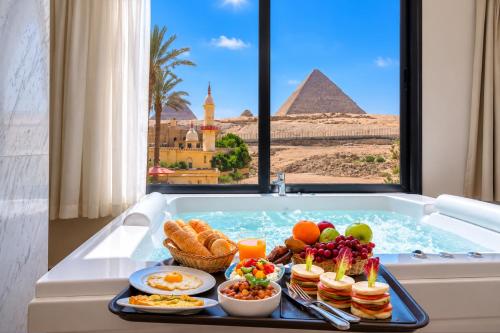 a tray of food in a bath tub with a pyramid at The Stay Pyramids Inn in Cairo