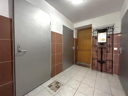 a bathroom with a door and a tile floor at Logement entier jardin clos parc chien A1 A29 5 mn in Herleville