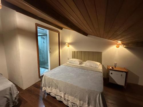 a bedroom with a large bed and a window at Bangalô Hospedagens in São Luís