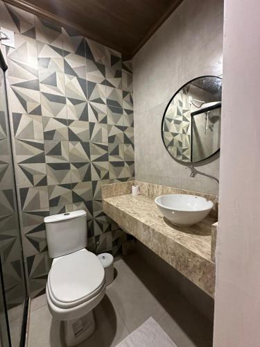 a bathroom with a toilet and a sink at Bangalô Hospedagens in São Luís