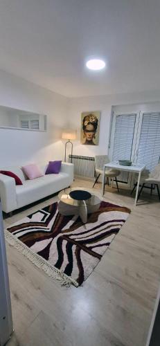 a living room with a white couch and a rug at See Love 2 in Zagreb