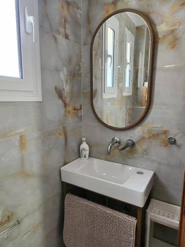 a bathroom with a sink and a mirror at Acro Studios in Skala Potamias