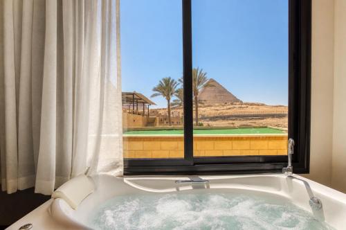 a bath tub in a room with a window at The Stay Pyramids Inn in Cairo