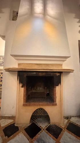 a brick fireplace in a room with a white wall at Riad Arous Chamel in Tangier