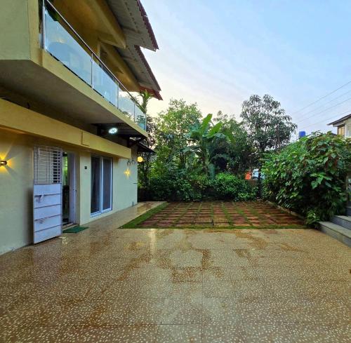 a house with a brick driveway next to a building at Eko Nest Grand 5BHK Villa in Lonavala