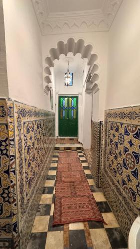 a hallway with a green door and a tile floor at Riad Arous Chamel in Tangier