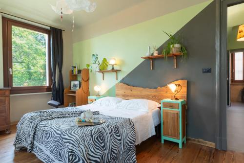 a bedroom with a large bed with a zebra blanket at Aurorina, appartamento con giardino in Torre Pellice