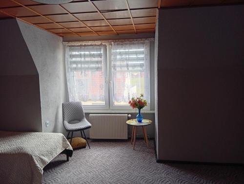 a bedroom with a bed and a window with a vase of flowers at Ferienhäuschen Berg und Tal in Harzgerode