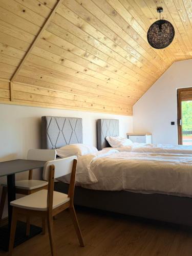a bedroom with a large bed with a wooden ceiling at Tri ville in Žabljak