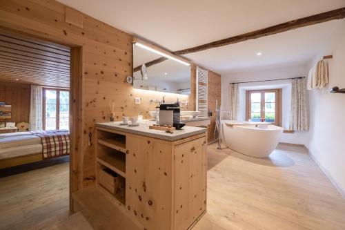 a bathroom with wooden walls and a tub and a sink and a bath tub at Relais & Châteaux IN LAIN Hotel Cadonau in Brail