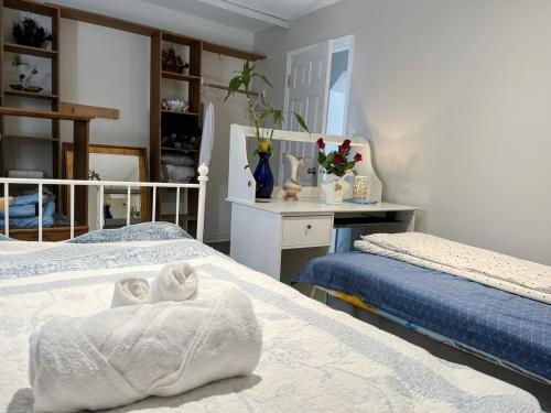 a bedroom with two beds and a desk in it at Richmond cozy room in Richmond