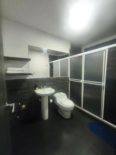 a bathroom with a toilet and a sink at Hotel Siglo 21 in Cali