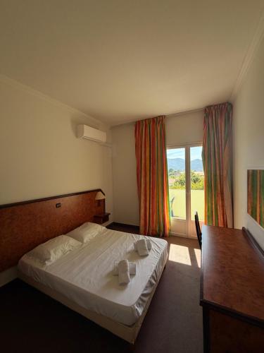 a hotel room with a bed and a window at Hotel Madame Mere in Saint-Florent