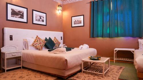 a bedroom with a large bed and a couch at Riad Ouarzazate in Ouarzazate