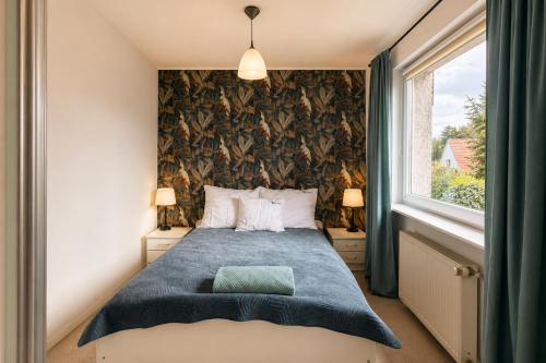 a bedroom with a bed and a large window at Apartamenty na Fali in Mrzeżyno