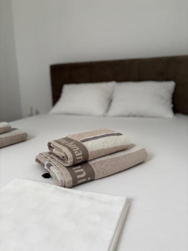 three towels sitting on top of a bed at Apartman AN12 in Neum