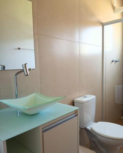 a bathroom with a sink and a toilet at Pousada Diamante in Piranguçu