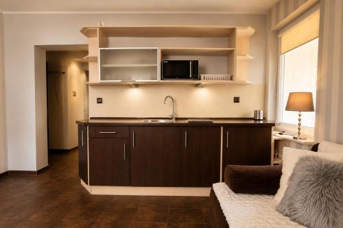 a kitchen with a sink and a microwave at Apartamenty na Fali in Mrzeżyno