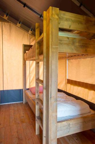 a bedroom with two bunk beds in a cabin at Camping De Kooiplaats in Schiermonnikoog
