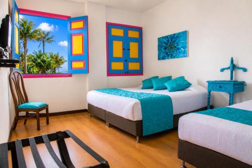 a room with two beds and a chair in it at La Posada de la Plaza in Salento
