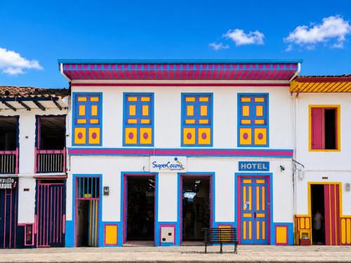 a white building with colorful doors and windows at La Posada de la Plaza in Salento