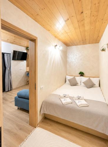 a bedroom with a large bed with a wooden ceiling at Royal Hill-Prince Chalet Bran- Mountain View and Hot Tub in Sohodol
