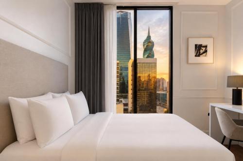 a hotel room with a bed and a large window at Hotel Mio Panamá in Panama City