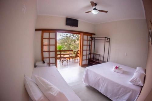 a bedroom with two beds and a balcony at Pousada Vale Verde com café da manhã in Lindóia