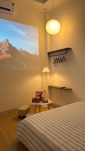 a bedroom with a bed and a painting on the wall at Lấp Ló Home in Danang