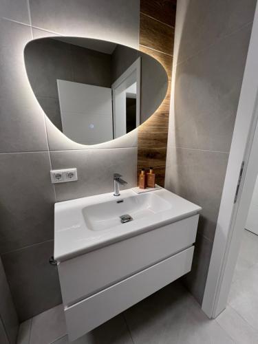 a bathroom with a white sink and a mirror at Apartman Rawda in Jajce