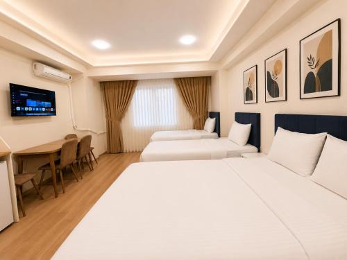 a hotel room with two beds and a table at Stay Istanbul Hotel in Istanbul