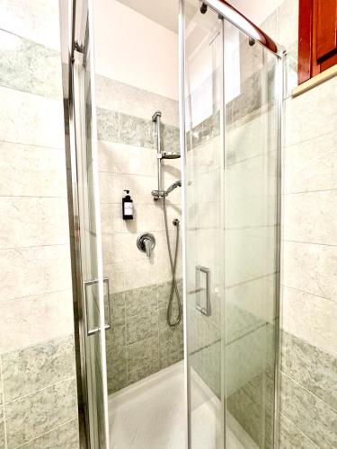 a bathroom with a shower with a glass door at White House Quartu in Quartu SantʼElena