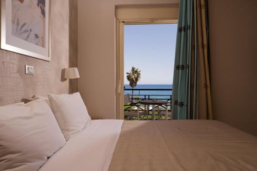 a bedroom with a bed with a view of the ocean at Plaza Hotel in Zakynthos