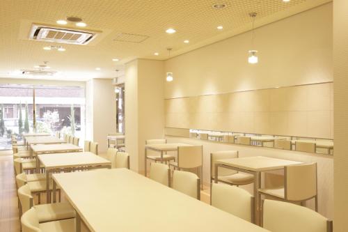 a dining room with tables and chairs and a chalkboard at Hotel Green City in Sendai