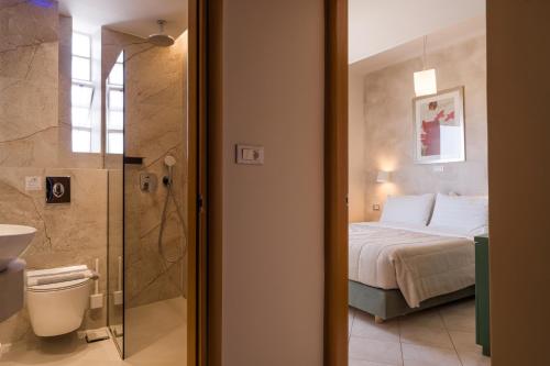 a bedroom with a bed and a bathroom with a shower at Plaza Hotel in Zakynthos